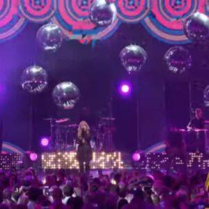 Large reflective disco mirror ball hanging at a party stage.