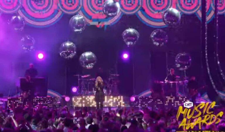 Large reflective disco mirror ball hanging at a party stage.