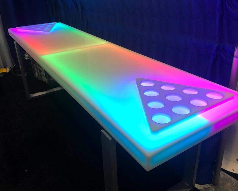 LED beer pong table with a multicolor illuminated surface and circular cup positions