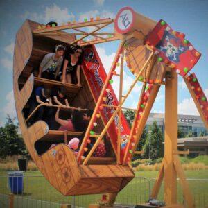 Children enjoying the Pirate Revenge amusement ride at an outdoor event.